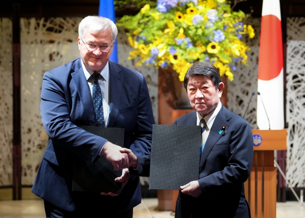署名済みの書簡を掲げて握手するシビハ・ウクライナ外相と茂木大臣