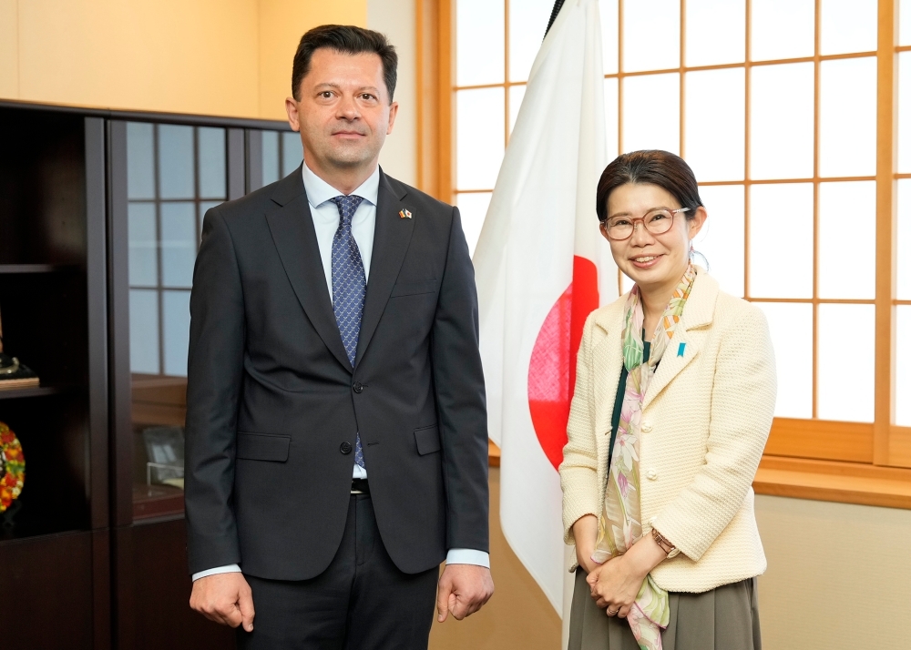 日本国旗前でミホフ大使と写真撮影する国光副大臣