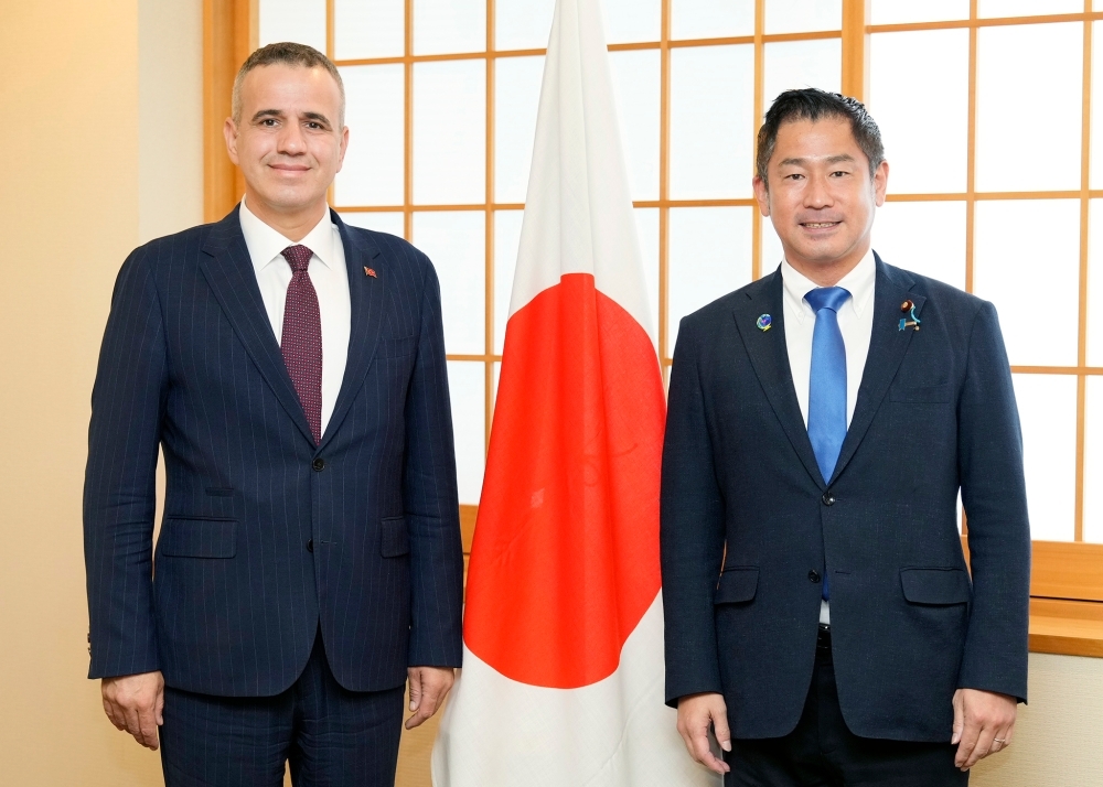 日本国旗の前で写真撮影に応じる大西外務大臣政務官とピリンチチ・トルコ・コミュニケーション庁副長官