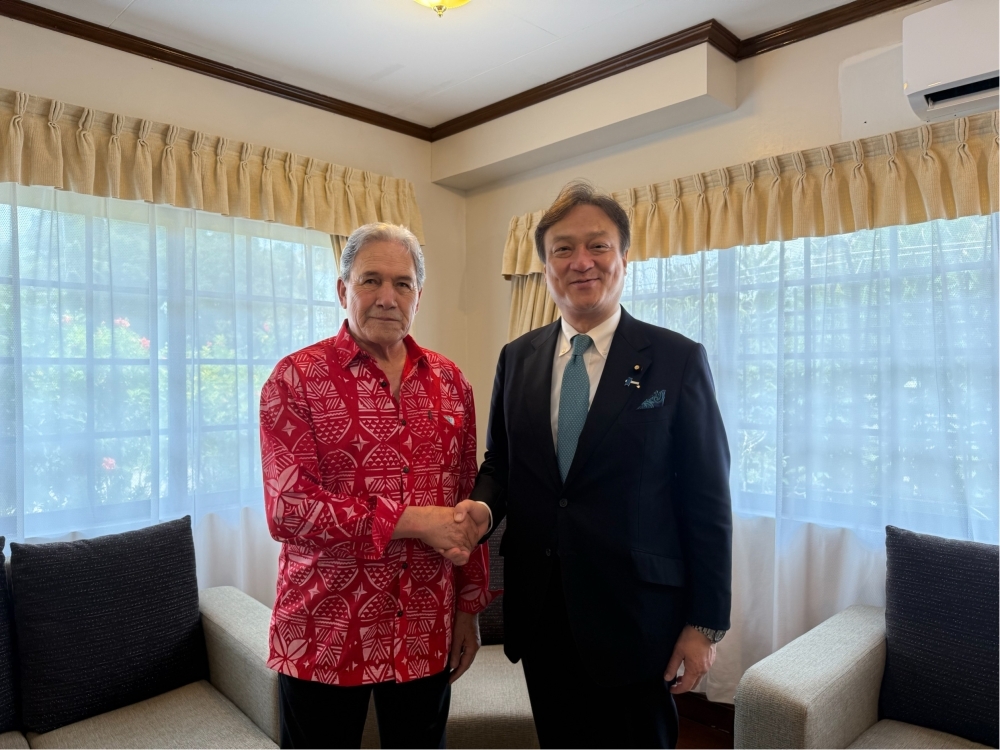 握手をする堀井副大臣とピーターズ・ニュージーランド外相