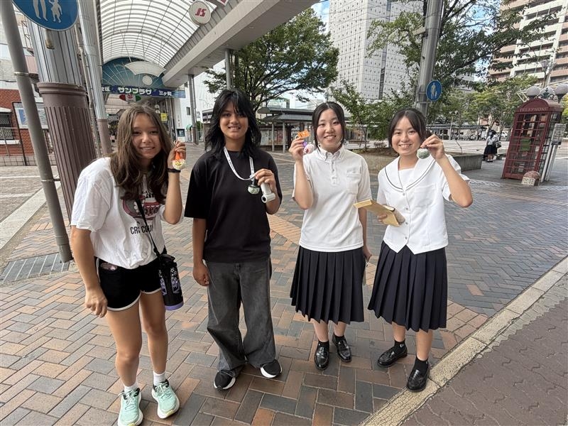 ピースサインをする商店街を散策する学生達