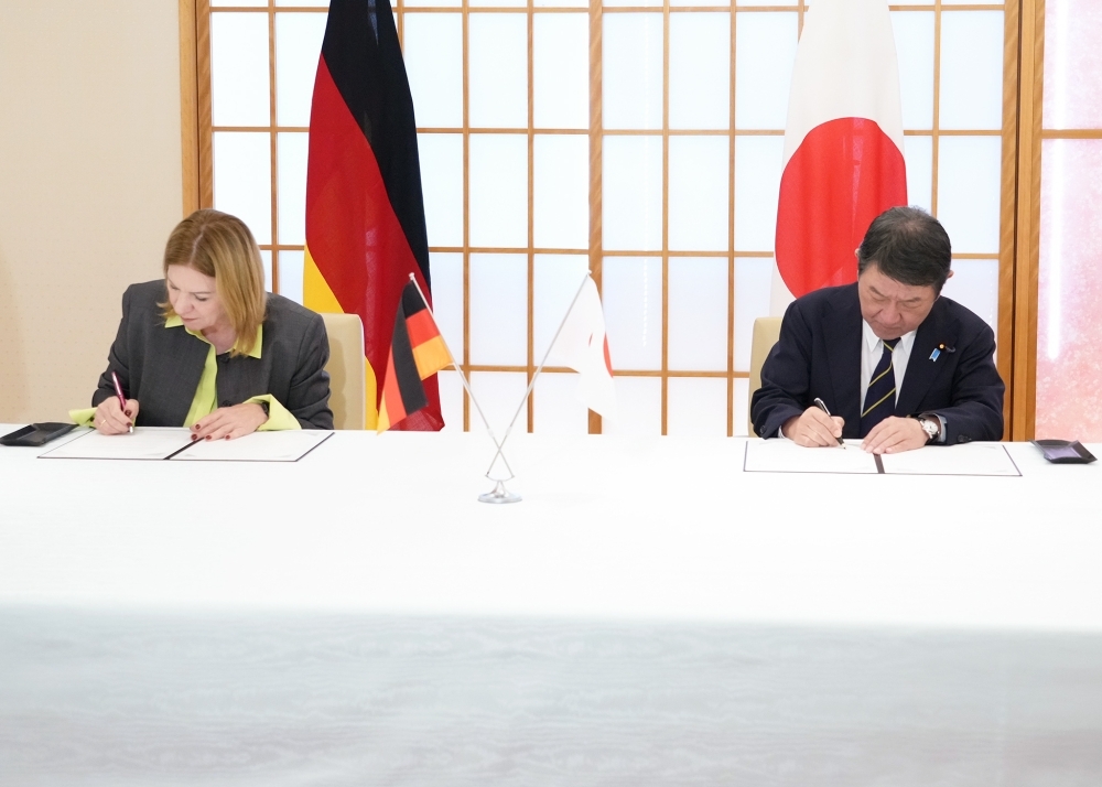 署名中の茂木外務大臣とペトラ・ジグムント駐日独大使の様子