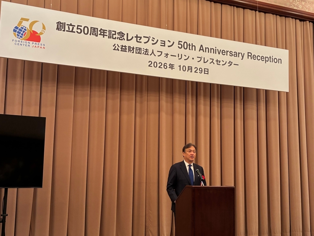壇上で挨拶する堀井副大臣。図上にはFPCJ50周年のプラカードが掲げられている。