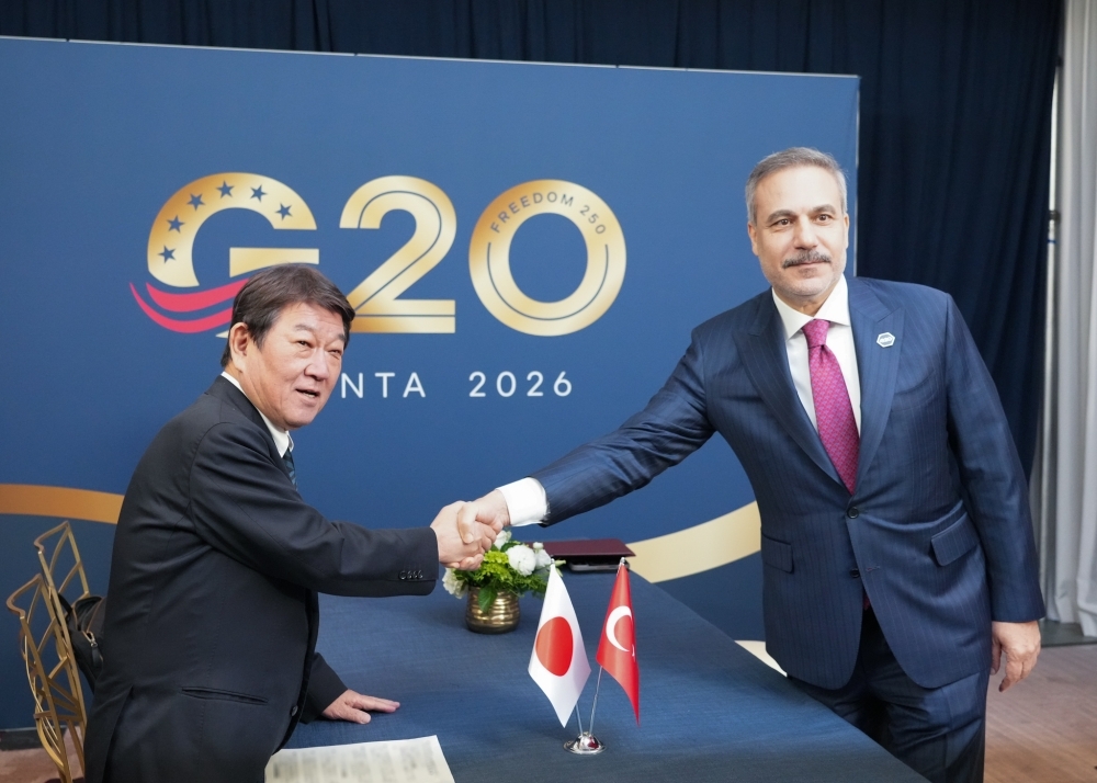 G20と書かれた壁を前にフィダン外相と握手する茂木外務大臣