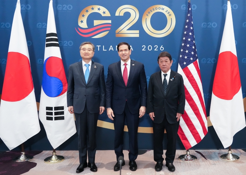 3国の国旗に挟まれて写真撮影する茂木外務大臣及びルビオ米国国務長官及び趙顕韓国外交部長官