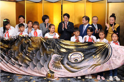 ベトナムの小学校関係者と交流する安倍総理大臣夫妻（中央）（2013年1月16日、ベトナム　写真提供：内閣広報室）