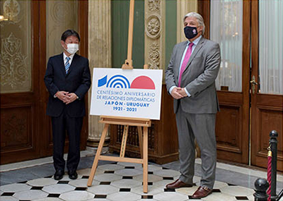 「日・ウルグアイ外交関係樹立100周年記念」ロゴマークを発表する茂木外務大臣とブスティージョ外相（1月6日、ウルグアイ・モンテビデオ）