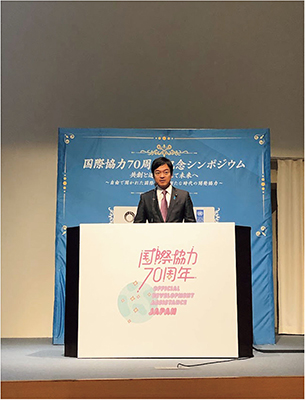 国際協力70周年記念シンポジウムで岩屋外務大臣の基調講演を代読する宮路拓馬外務副大臣（12月17日、東京）