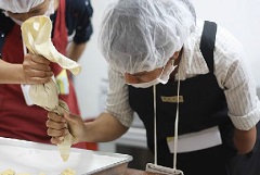 (写真）クッキー研修-ラオス北部からやってきた片手が欠損している女性障害者。
