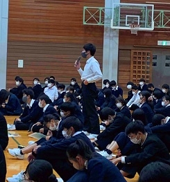 （写真3）マイクを持っ手質問をする男子生徒の様子