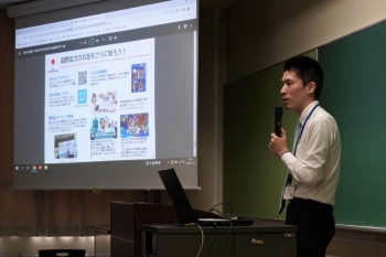 国際協力局政策課の山崎主査がスクリーン画面を使って講義をする様子