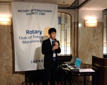 東京丸の内ロータリークラブの会員に向けて話す講師の丸森首席事務官の様子。
