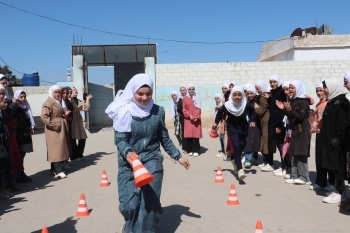 三角コーンをもって笑顔で走り回る女の子たち