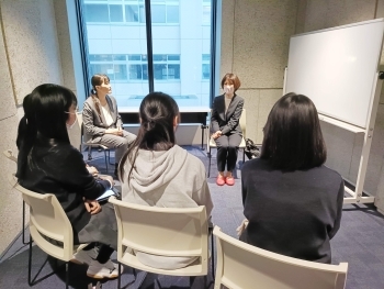 講座後の少人数での意見交換の様子。講師を囲み生徒が数名椅子に座って話を聞いている。