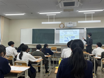 教室前方の黒板前で話をする講師の様子。