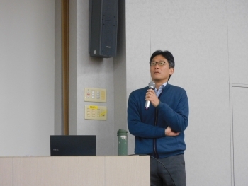 講師が壇上でスライドを用いて、日本のODAや人道支援について説明している場面。