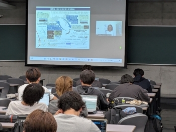 オンラインで講義を行っている在ラオス日本大使館の吉橋明日香一等書記官とスクリーンの様子