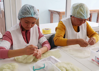 イシククリ州のフェルト製品生産所で作業する女性達の写真