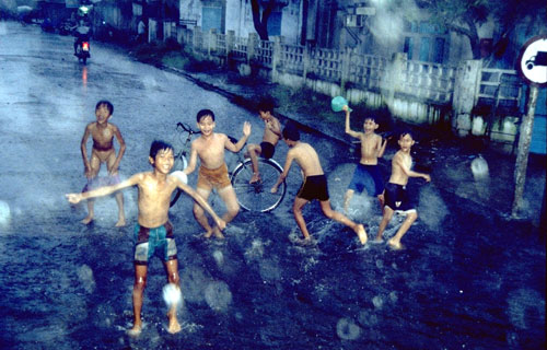スコールの中でたわむれる子どもたちの写真