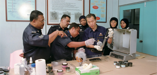 マレーシア警察庁警察科学捜査研究所において、マレーシア国家警察の科学捜査能力向上を目指すため、指紋採取や鑑識の技術指導を行っている日本人専門家（写真：菅原アラセ/JICA）
