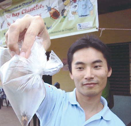 住民から保健省に届けられたサシガメを手にする吉岡さん（写真：吉岡浩太）
