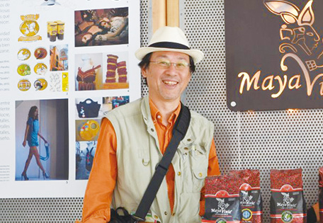 マヤビニック・カフェの看板の前に立つ山本さん（写真：山本純一）