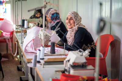 「オアシス」において、縫製技術の職業訓練に励むシリア人難民女性(写真:UN Women)