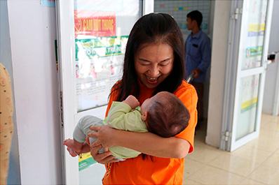 UNFPAが支援する少数民族地域の産婦人科にて赤ちゃんを抱く筆者