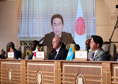 チュニジアで開催された第8回アフリカ開発会議(TICAD 8)の開会式において、テレビ会議方式でスピーチを行う岸田総理大臣と総理特使として対面形式で出席する林外務大臣(2022年8月)