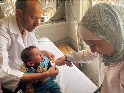 パレスチナのガザ市において開設した簡易診療所で医師によるスクリーニングを受ける乳幼児（写真：特定非営利活動法人パレスチナ子どものキャンペーン）