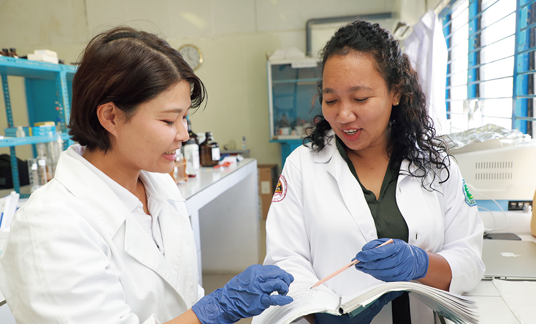 東ティモールにおいて、薬品保管庫でJICA海外協力隊員が現地職員と共に実験を行う様子（写真：JICA）