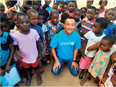 モザンビークでUNICEFが支援する就学前教育プログラムを受けているこどもたちとUNICEFモザンビーク事務所の原田匡剛（教育担当官）（写真：UNICEF Mozambique）