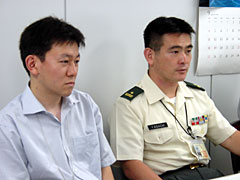 （写真）左：阿部俊宏事務官、右：足立吉樹3等陸佐