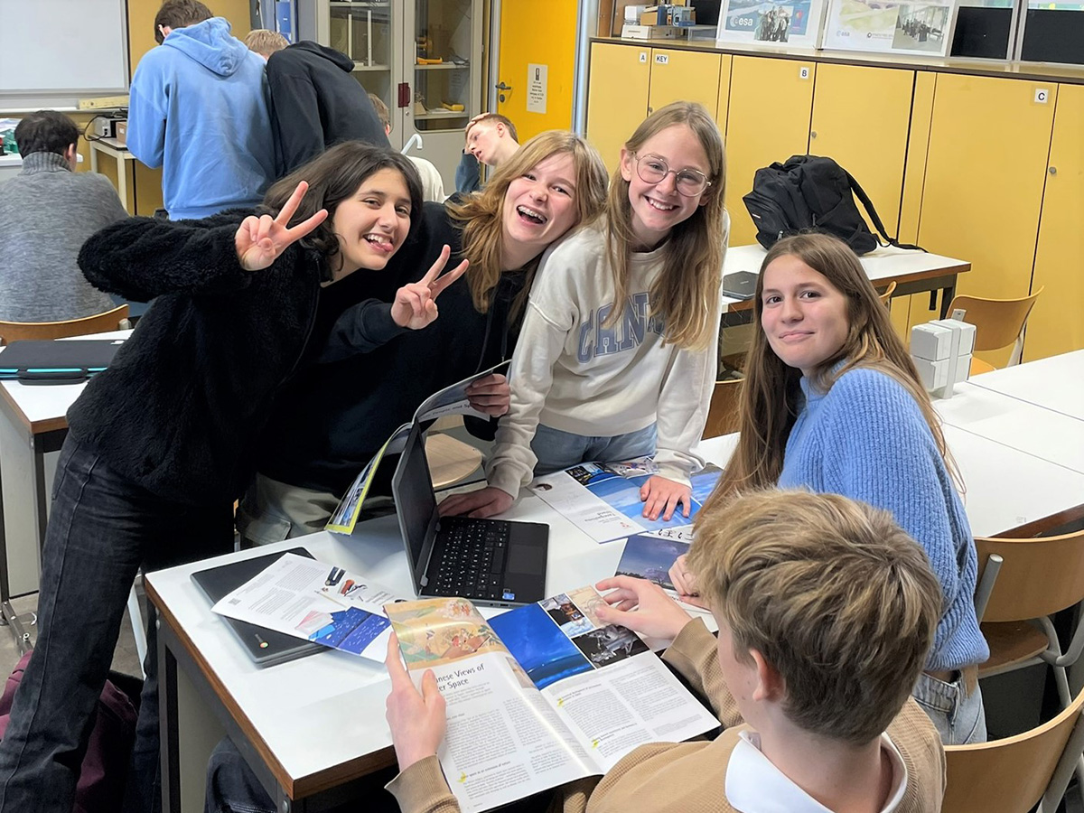 教室でカメラに向かってポーズをとる生徒たち