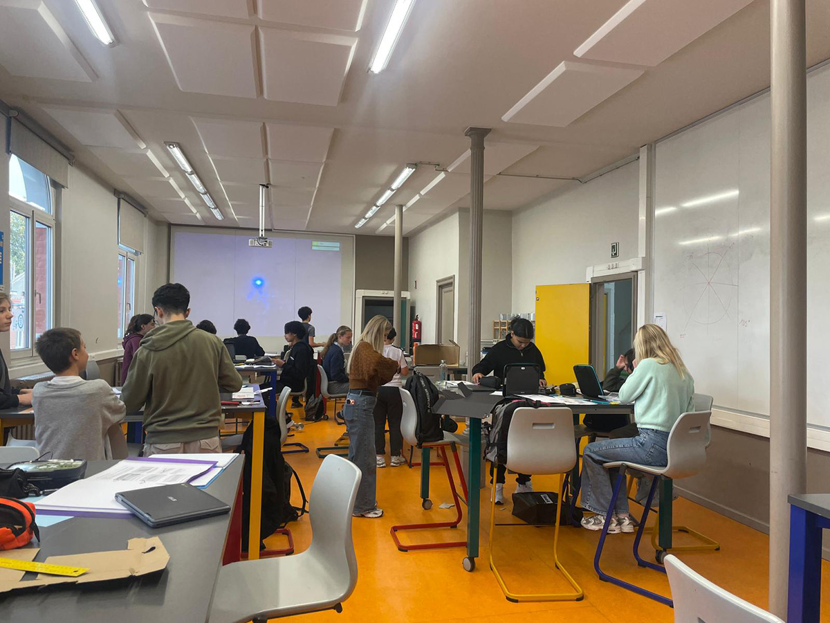 教室でカメラに向かってポーズをとる生徒たち