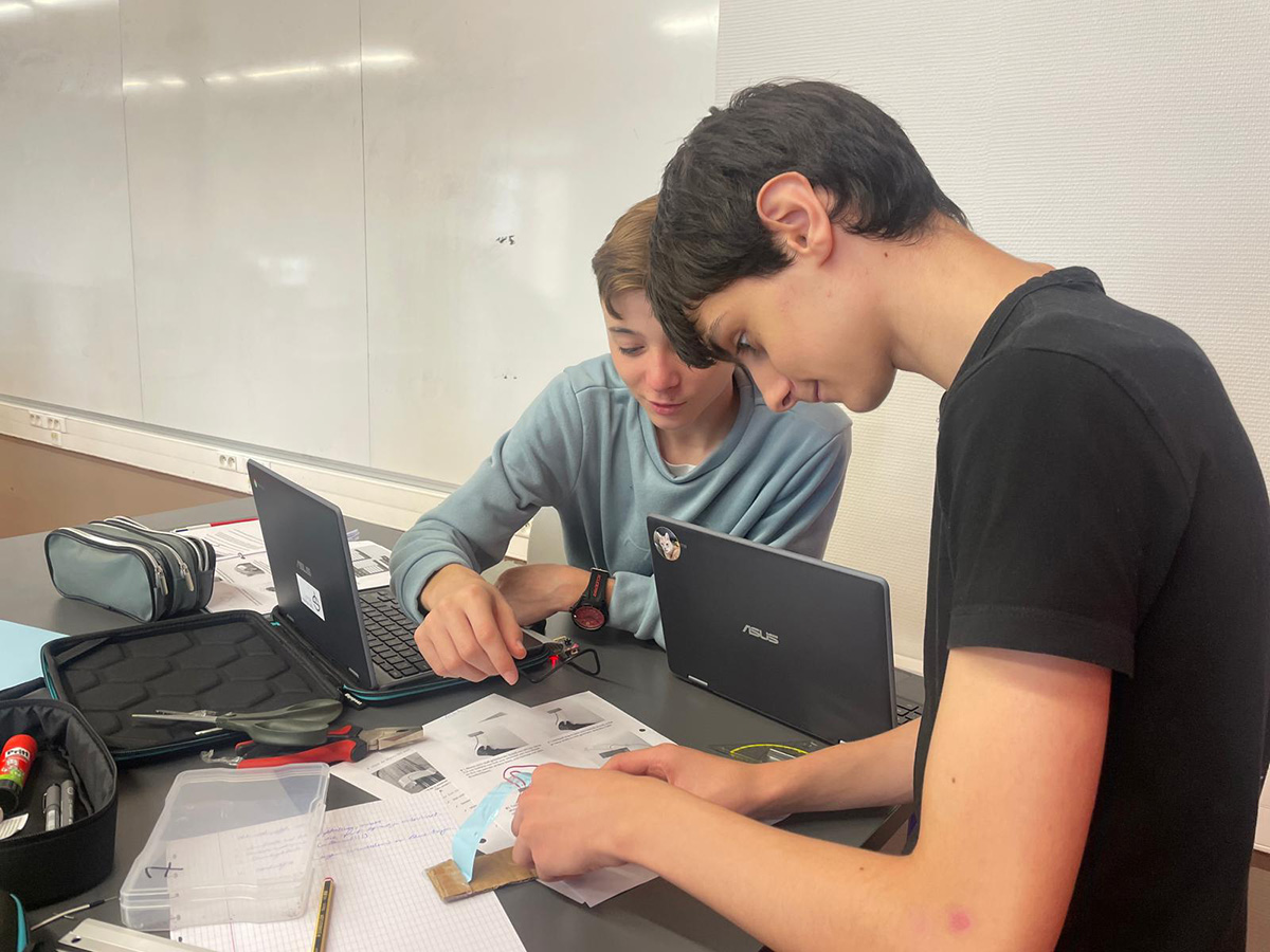 教室でカメラに向かってポーズをとる生徒たち