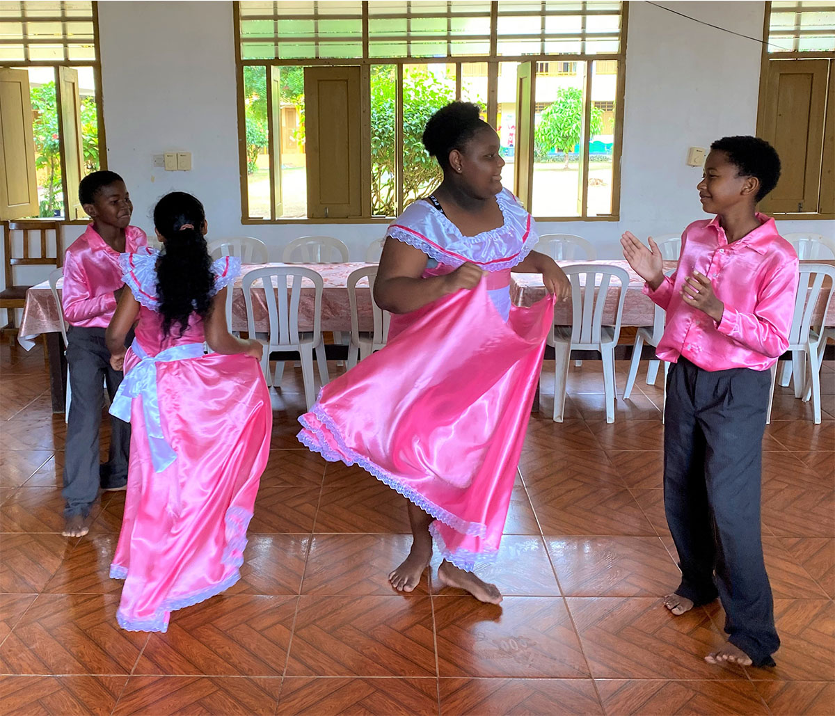 ピンクの衣装でペアのダンスをする生徒たち