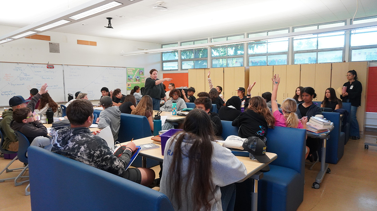 手をあげる生徒を指差す先生