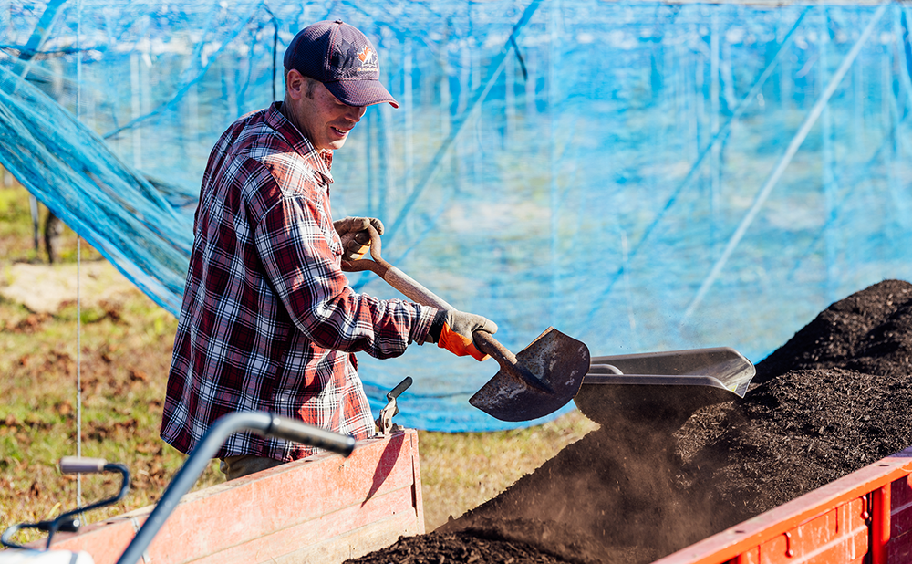 Lapierre carring soil with a shovel to work in the field