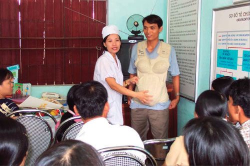 A man wearing a pregnancy simulator and learning about reproductive health including family planning at a health center (Photo: Japanese Organization for International Cooperation in Family Planning [JOICFP])