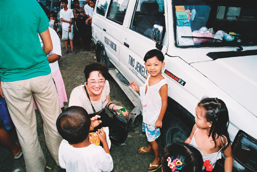 Ms. Sato interacting with Filipino children, smiling (Photo: Association for Promotion of International Cooperation (APIC))
