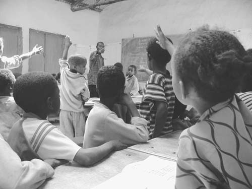 School children cheerfully raising their hands to answer questions (Ethiopia) (Photo: JICA)
