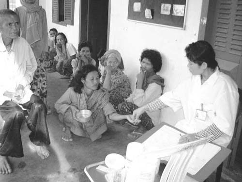 A medical worker checking the drug compliance of a patient (Project for Tuberculosis Control, Cambodia) (Photo: Japan Anti-Tuberculosis Association)