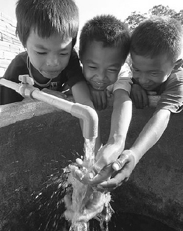 Children gathered around a newly built water spout in Phnom Penh, Cambodia (Photo: Kenshiro Imamura/JICA)