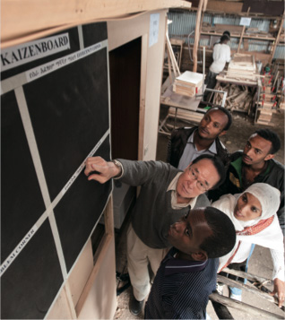 A Japanese expert visits a tiny furniture manufacturing company in Addis Ababa, Ethiopia to talk about the KAIZEN Board. (Photo courtesy of Kenshiro Imamura/JICA)