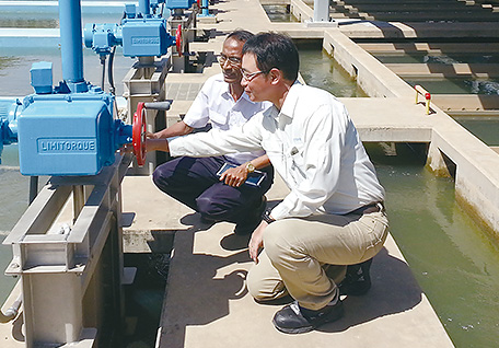 Confirmation is made about the valve update plan with the manager in charge of water purification at the Phum Prek Water Treatment Plant in Phnom Penh. (Photo: Takayuki Kawasaki)
