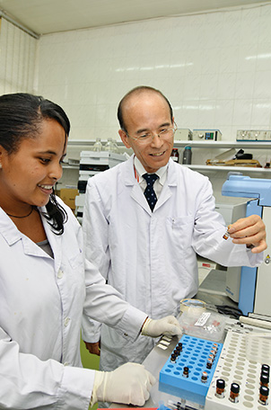 Mr. Yoshio Izawa, who is in charge of the Project for Strengthening of Agricultural Pesticide Residue Analysis System, guiding an assistant to detect agricultural pesticide residues in Ethiopia. (Photo: Takeshi Kuno / JICA)
