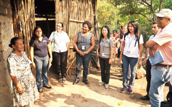Beneficiaries of the Life Improvement Network “REDCAM” explaining to JICA and FAO officials that a family of the Gualococti village of Morazán, El Salvador, has proposed an action plan through the subject-specific training of the “Sustainable Rural Development through the Life Improvement Approach,” and that its implementation has led to the improvement of the living environment. (Photo: Ernesto Manzano / JICA)