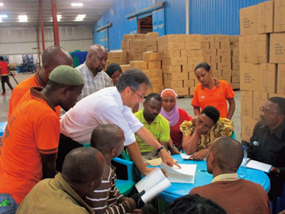 Tanzanian staff receiving a briefing from a JICA expert dispatched for Phase 2 of the Project on Strengthening Manufacturing Enterprises through Quality and Productivity (Photo: JICA)