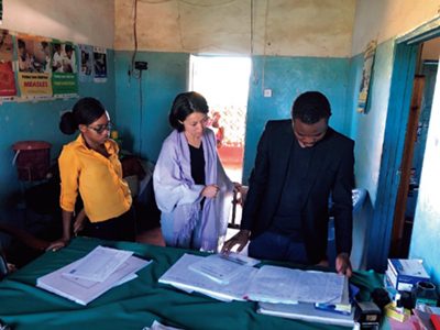 A local personnel checking whether the date of delivery, amount, inspection results, and other details are accurately recorded for tuberculosis specimens, under the guidance of a JICA expert as part of the technical cooperation project, “Project for Strengthening Basic Health Care Services Management for Universal Health Coverage in Zambia” (Photo: JICA)